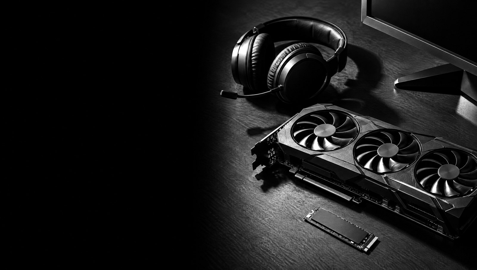 Carte graphique, SSD et casque sur une table, photo noir et blanc