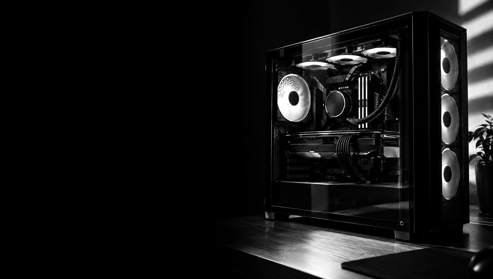 PC gamer avec panneau vitré dans une pièce sombre, photo noir et blanc